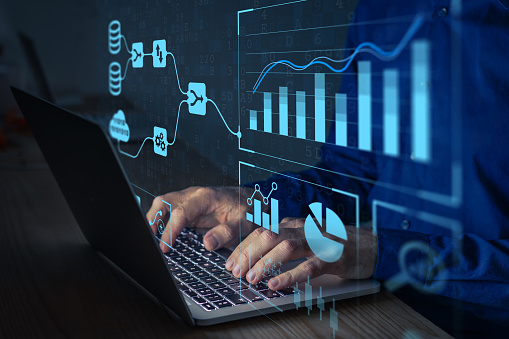 Anklyticx - A man typing on a laptop with graphs on it.