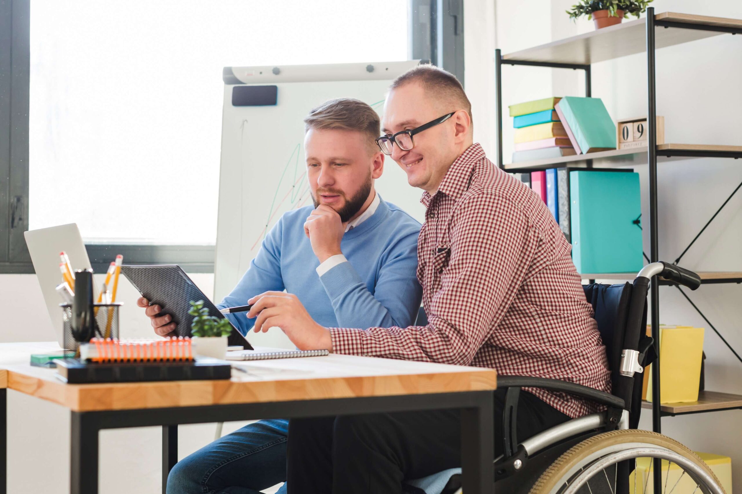 Anklyticx - Two men in wheelchairs sitting at a desk.