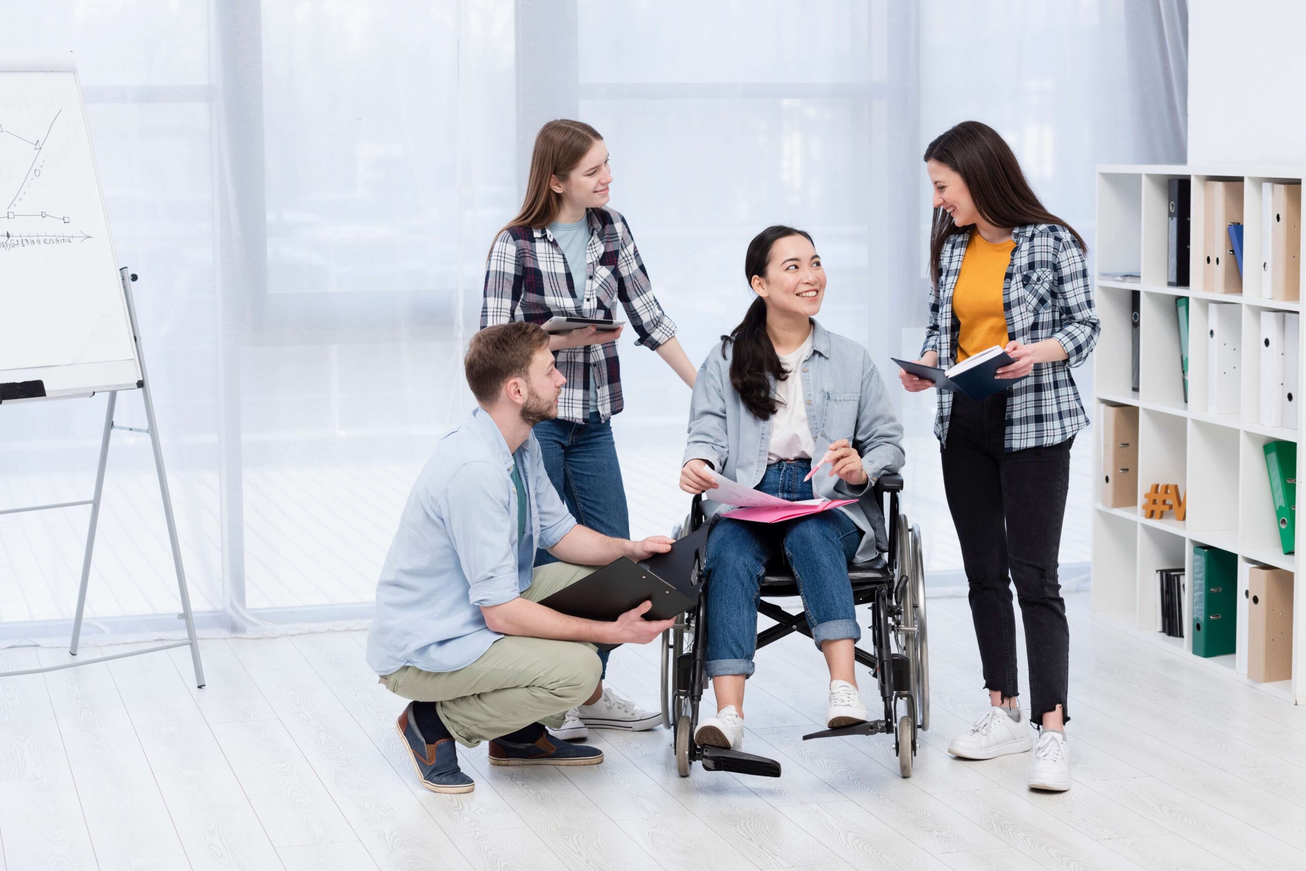 Anklyticx - A group of people sitting around a woman in a wheelchair.