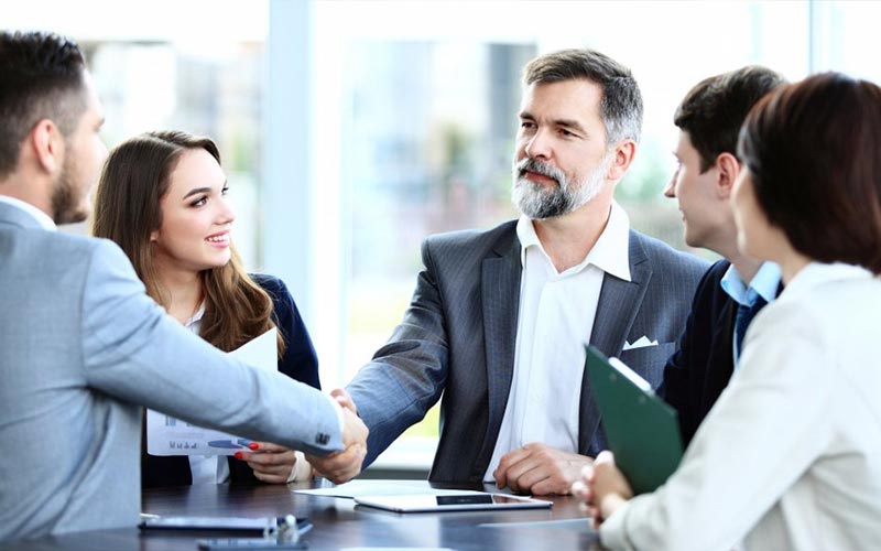 Anklyticx - A group of business people shaking hands at a meeting.