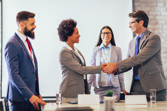 Anklyticx - A group of business people shaking hands at a meeting.