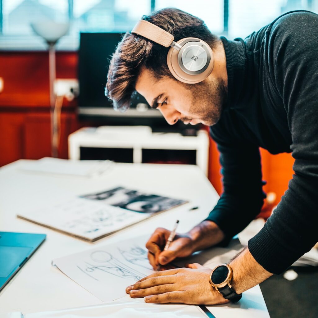 Anklyticx - A man wearing headphones is working at a desk.