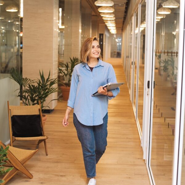 Anklyticx - A woman walking down a hallway in an office.