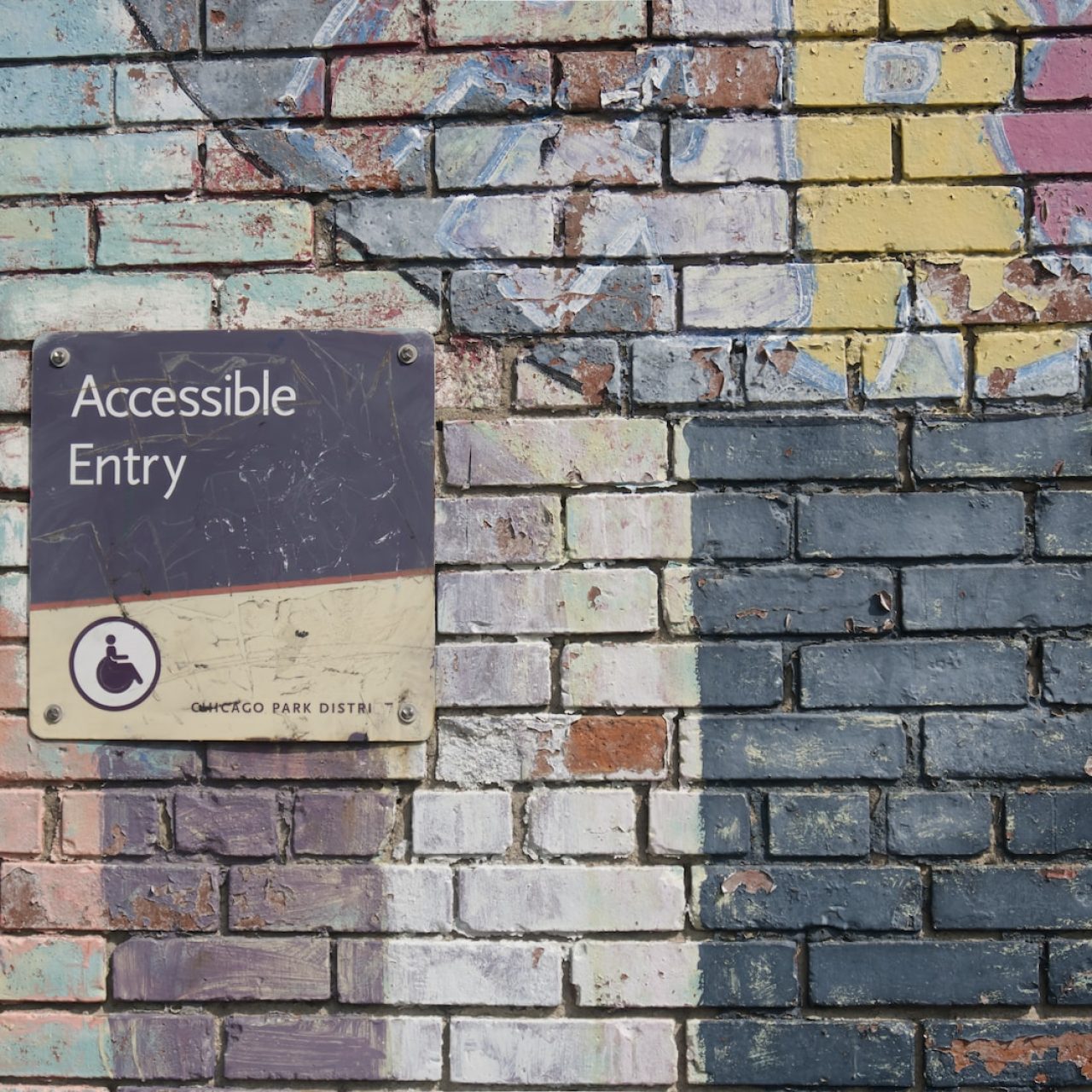 Anklyticx - A sign that says accessible entry on a brick wall.